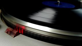 Close up of turning vinyl record with red light of stroboscope for a retro music feeling, selective focus