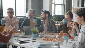 Businesspeople enjoyng lunch break at work eating pizza and drinking talking laughing in office room. Coworking and corporate meals concept. - Powered by Shutterstock - Get 15% off with code: PIKWIZARD15