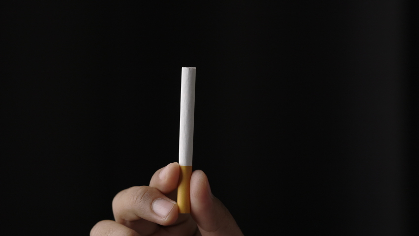 A young man with a cigarette He is going to smoke. Close up hand man showing a cigarette. World No Tobacco Day | Shutterstock HD Video #1065949648