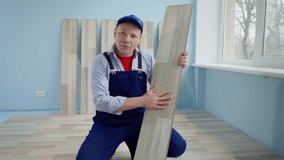 portrait of videoblogger during renovation showing thumbs up, man in a working uniform talks on camera about the laminate