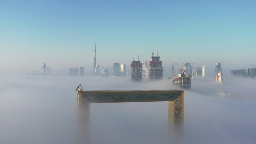Aerial view of Dubai frame and skyline rising from dense fog during winter season | Shutterstock HD Video #1065954514