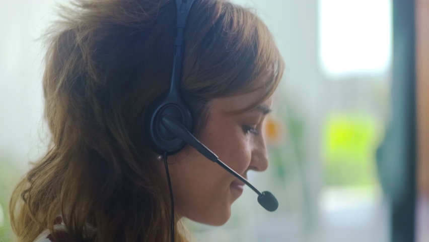 Close up of young female service phone operator focus on sales agent woman in headset use laptop answers incoming calls talk with client provide professional support to customers sell company product Royalty-Free Stock Footage #1065957202
