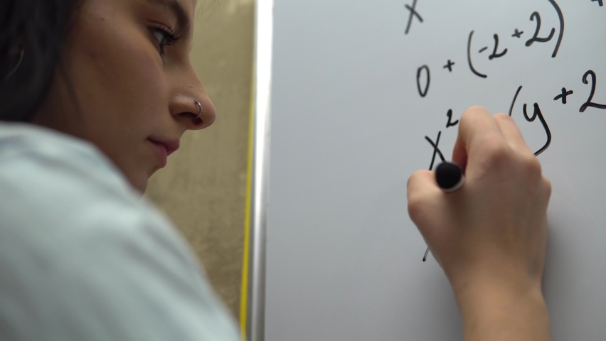 Female student writing math equation on whiteboard. Math algebra lesson, education  | Shutterstock HD Video #1065960703