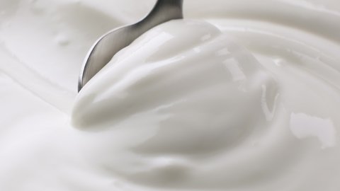 Sour cream with spoon, fresh greek yogurt close up