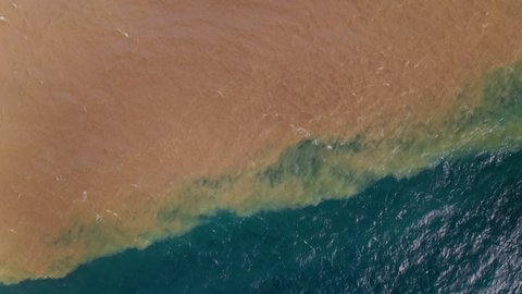 Dirty Polluted Water flowing into a blue Ocean from a Sewage outlet close to the beach.
Stain of oil or fuel on water surface, nature pollution by toxic chemicals, dirty sea concept.