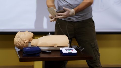 KYIV, UKRAINE - August 2020: Training course for first aid. Medical worker giving instructions for saving life in resuscitation center. Dummies for demonstration on the table.