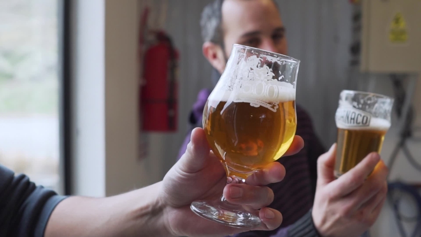 Three Men Toasting With Their Glasses Of Beer In The Brewery - Close up slowmo