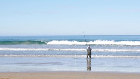  Lorne, Australia June 2020 - a man casting a fishing line into the ocean along great ocean road.