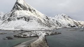Aerial of car driving in winter paradise in Lofoten Islands, Norway
