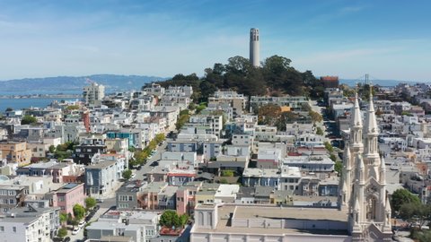 Cinematic San Francisco cityscape background aerial. Coit tower landmark and Saints Peter and Paul Church beautiful white pikes architecture. Street view in historic residential area. Summer sunny day