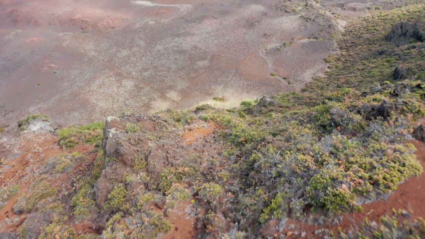 Drone flying over rustic cabin in the volcano crater at Haleakala National Park, Maui, Hawaii, USA. Wilderness adventure and nature travel. Tourists relaxing at the picnic table after hard trail hike