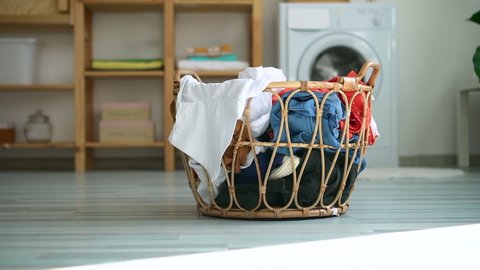 prepared basket with dirty casual clothes on floor of bathroom with washing machine. Spbd domestic chore, cleaning, appliance concept. laundry for housework, housekeeping
