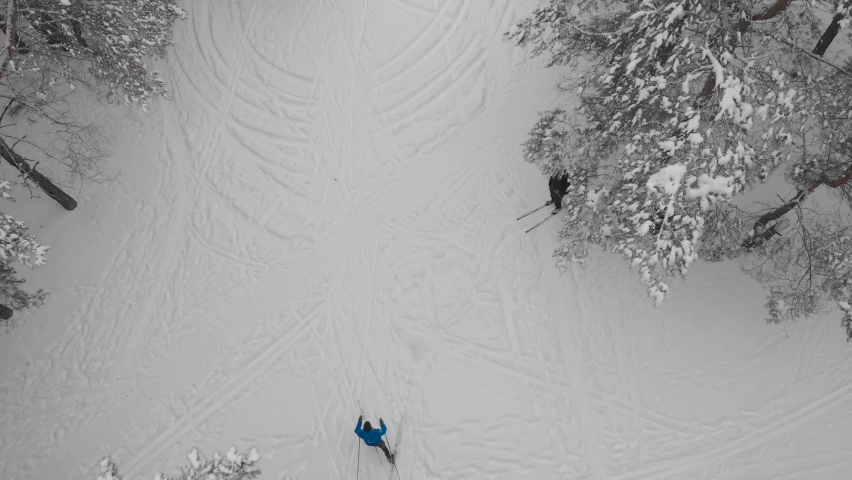 Top view. Sporty man is engaged in cross-country skiing in the winter forest.
