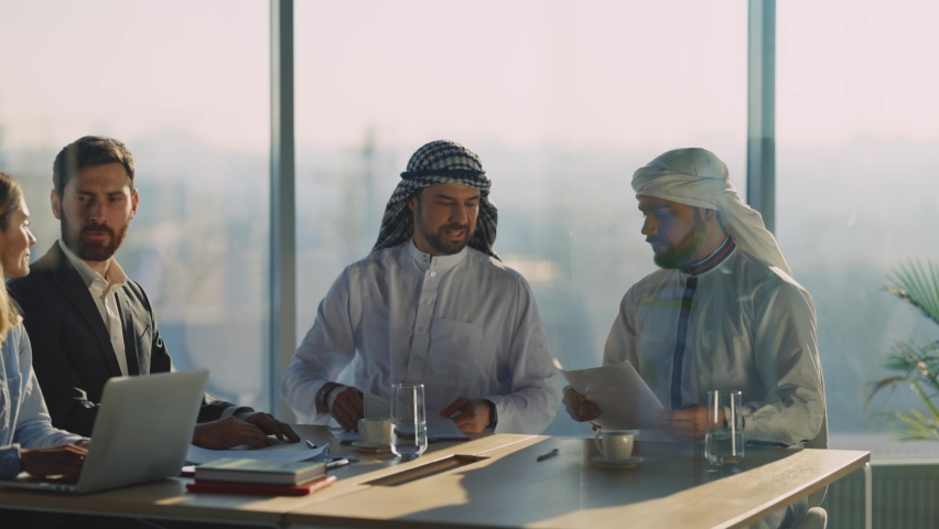 Successful male female couple negotiating with arabic businessmen signing contract shaking hands for cooperation. International relations. Agreement. Royalty-Free Stock Footage #1065995503