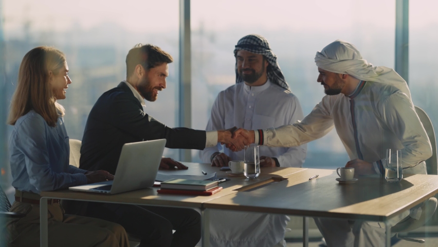 Successful male female couple negotiating with arabic businessmen signing contract shaking hands for cooperation. International relations. Agreement. | Shutterstock HD Video #1065995503