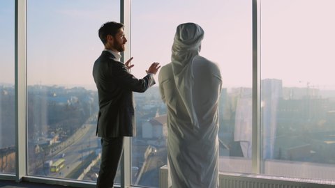 Diverse Biusiness Couple of Arab Rich Businessman Talking with Office Manager Shaking Hands Discussing Agreement for Investment. Muslim Investor. Cooperation.