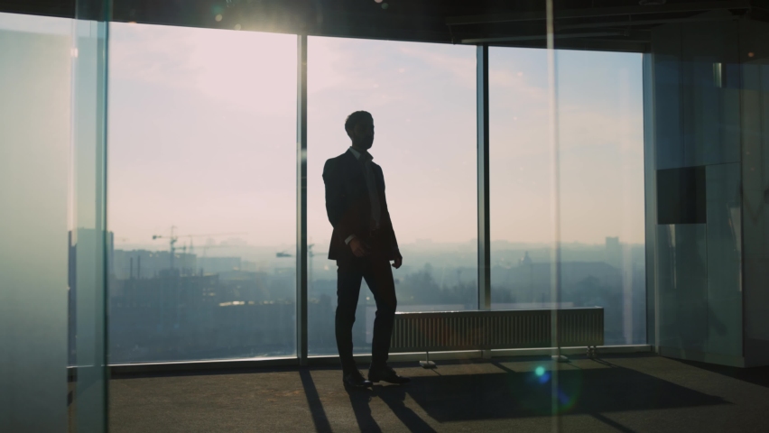 Young Adult Caucasian Entrepreneur Looking into Window Generating New Successful Business Ideas Contemplating Future Staying in Modern Office. Royalty-Free Stock Footage #1065995641