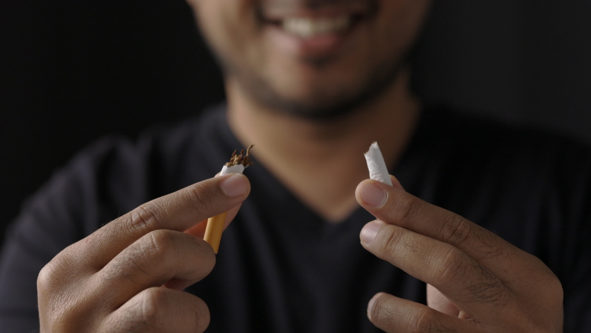 World No Tobacco Day. The young man quit smoking for his good health. He broke a cigarette in two | Shutterstock HD Video #1066004638