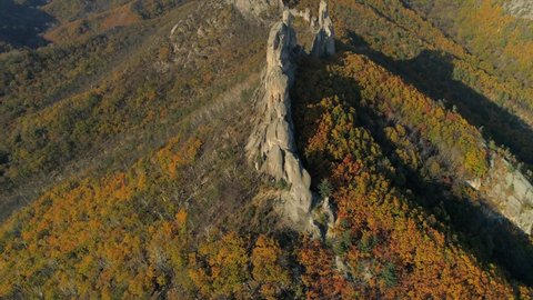 From great height epic Russia Far East natural landscape Lazovsky reserve ancient giant stones cliffs mystical place of power on top of hills mountains covered with yellow autumn forest. Open space