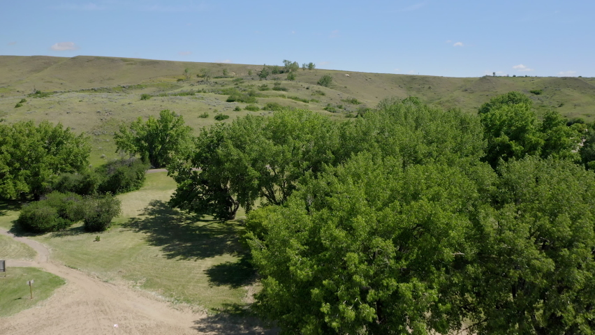 Green Foliage Hillside Landscape Under Bright Sunny Day In Lake Diefenbaker Saskatchewan, Canada. - Aerial Drone Shot