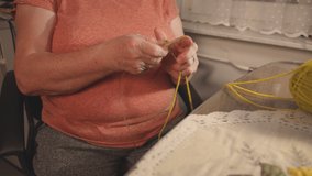 Old woman knitting sock during quarantine