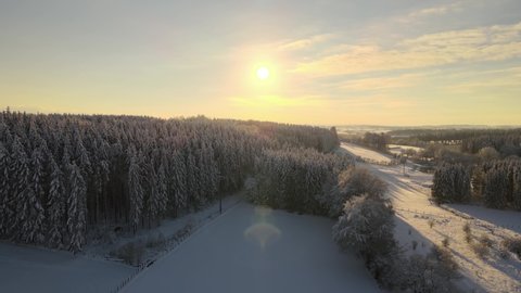Sunny snow hill in the belgium eifel ,  ardennes. Snow landscape aerial drone view sunset