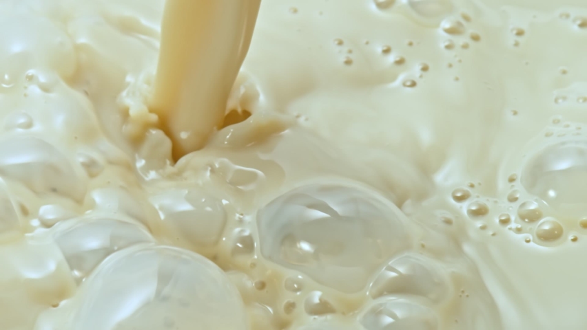 Milk Pouring with crown splash in milk pool with ripples. | Shutterstock HD Video #1066032022