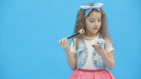 4k slowmotion video where little girl doing makeup looking in the mirror.