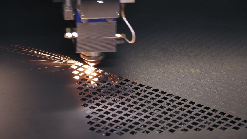 Laser cutting machine for sheet metal. close-up. modern machine with CNC fiber laser is cutting patterns on sheet metal plate. bright burning sparks fly from laser beam during cutting process Royalty-Free Stock Footage #1066038397