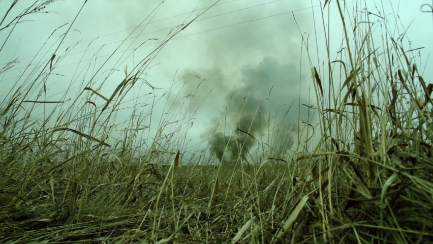 Fire in Steppe. Black Pillar of Smoke on Horizon. Careless Handling of Fire. View from High Dry Grass. Poisoned Atmosphere. Subjective Camera. Autumn. Fire Hazardous Season. Destruction of Ecosystems