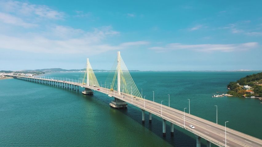 Cinematic aerial shot ofAnita Garibaldi bridge above the turquoise color brazilian ocean, located in Laguna, Santa Catarina, Brazil