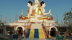 Thailand temple with big Buddha statue on background blue sky. Beautiful Landmark of Asia. Asian culture and religion. 4K Aerial view