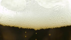 Beer bubbles in pint glass filmed in close up slow motion footage