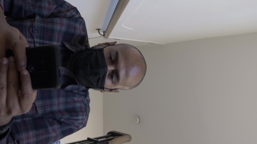 Adult Male Wearing Face Mask Checking Mobile Sitting Down On Stairwell. Low Angle, Vertical Video, Locked Off | Shutterstock HD Video #1066075855