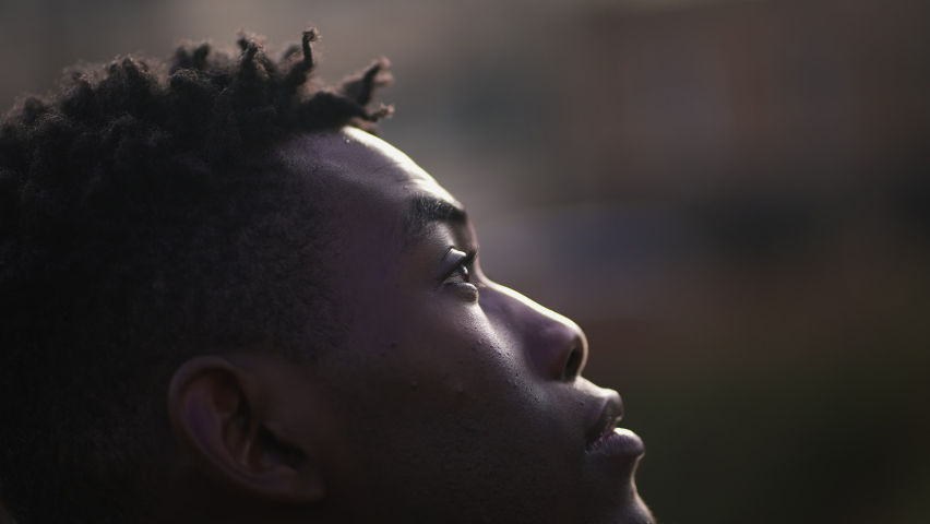 Meditative African man closing and opening eyes looking at sky smiling with FAITH and BELIEF | Shutterstock HD Video #1066077775