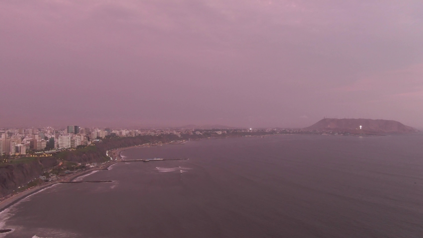 Cityscape Twilight, aerial shot, pink sky, ocean, cross catholic