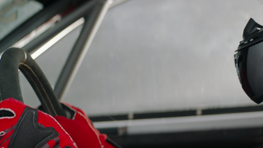 CU portrait of sports car driver closing helmet visor, starting a race on a speedway. Shot with 2x anamorphic lens Royalty-Free Stock Footage #1066088197