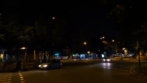 Barcelona, Spain - Circa 2019: Almost empty roundabout in the evening night in central Barcelona with few cars taxis and pedestrians