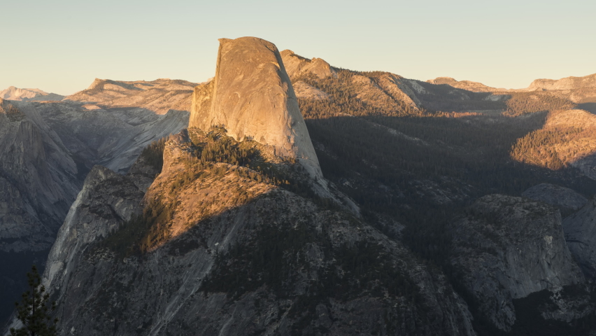 Time lapse sunset in Yosemite Valley National park USA. Scenic Half Dome rock in mountain wilderness. Sun light shining over massive summit peak into night. World famous landmark landscape. USA nature