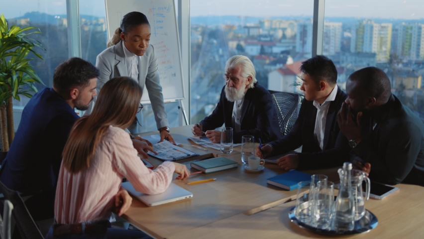 African Leader Businesswoman leading Corporate Meeting Event Discussing Paper Plan Contract with Multi-Race Colleagues in Office Cabinet Boardroom. Royalty-Free Stock Footage #1066102741