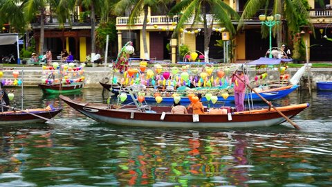 Hoi An, Vietnam - June 29, 2020 : Vietnamese people float on a wooden boat on the river water along the waterfront in Hoi An old town, Vietnam