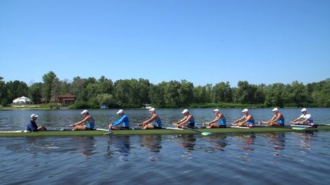 Rowing team summer training. 8 athletes rowers in a boat in the river Dnipro. City area in Kiev, Ukraine