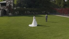 Newlyweds. Lovely caucasian bride groom walking in park grass. Holding hands. Happy wedding couple family. Romantic love of man and woman. Bride in wedding dress. Bridegroom in jacket. Aerial view