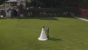 Newlyweds. Lovely caucasian bride embracing groom in park making a kiss. Happy wedding couple family. Romantic love of man hugging woman. Bride in wedding dress. Bridegroom in jacket. Aerial view