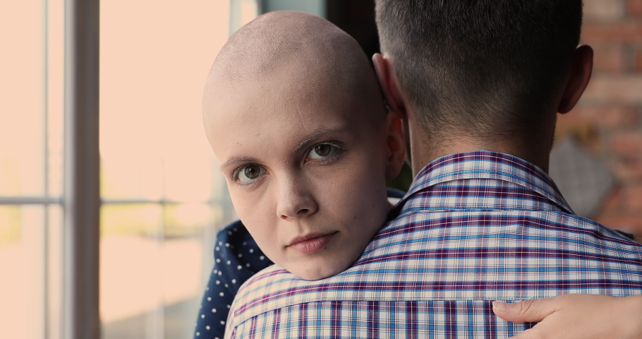 Close up face of bald female cancer patient hugging beloved man, rear back view. Sick woman look at camera smiling hoping for recovery, express gratitude to husband for support and compassion concept | Shutterstock HD Video #1066120921