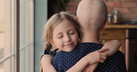 Daughter tight hug mother cancer patient show support give tenderness in hard period of rehab, mom shaved bald head close up back view. Unconditional love, life value, motivation to struggle concept