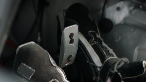 CU view of driver's legs pressing on pedals while racing inside a sports car. Shot with 2x anamorphic lens