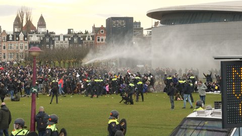Amsterdam, Netherlands, January 24, 2021. Riot police charging corona demonstration with water canon. 