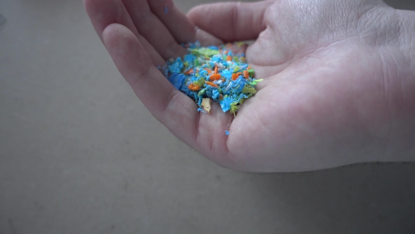 Side view of micro plastics falling from a human hand. Slow-motion of waste non-recyclable plastic. Selective focus on the hand. Environmental issues, global warming, and climate change concept. | Shutterstock HD Video #1066142191