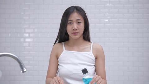 Daily routine concept of 4k Resolution. Young Asian woman gargling in the bathroom.